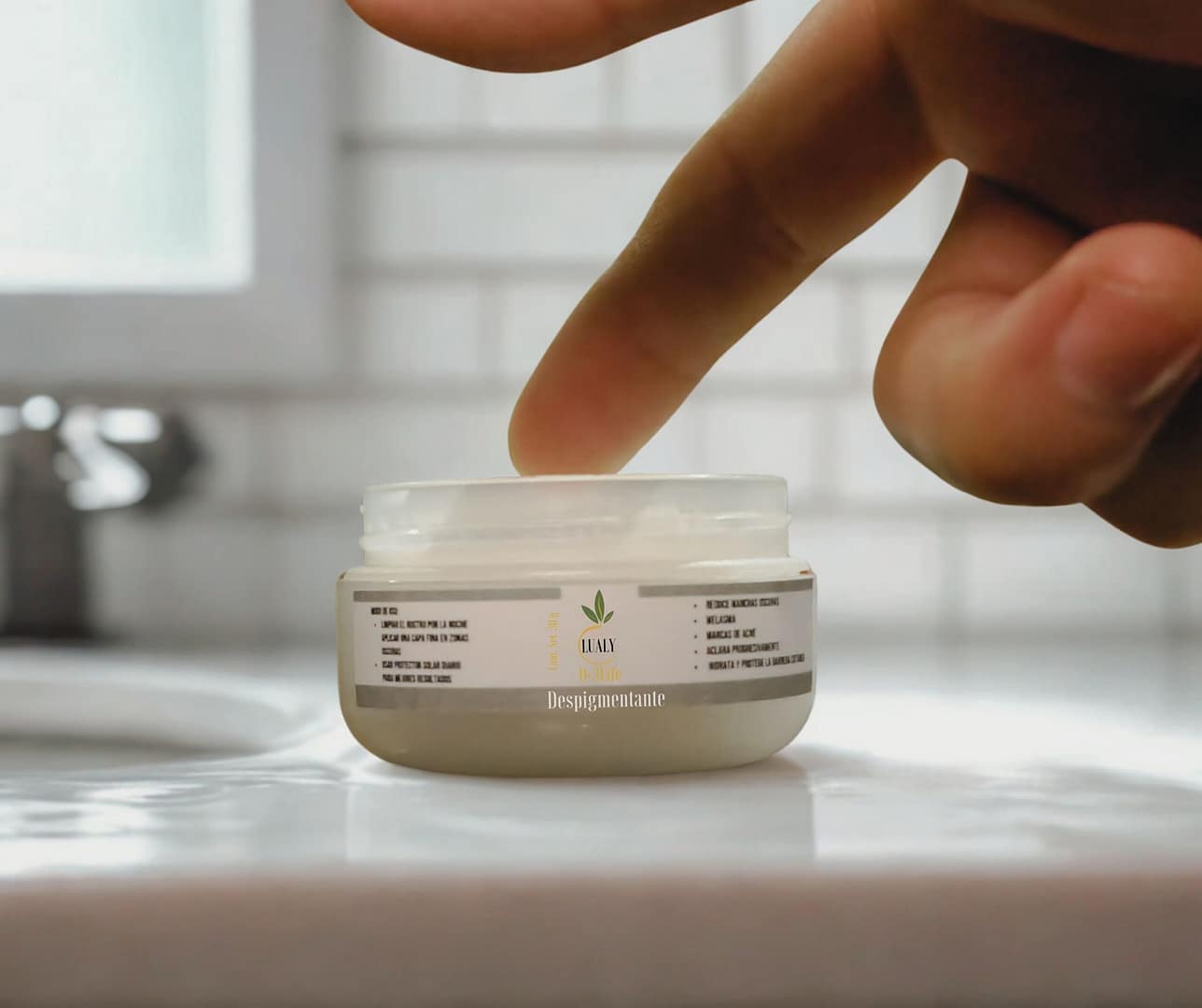 Una mano colocando un pote de la crema despigmentante con ozono en un lavabo, para un tratamiento de manchas y pecas.